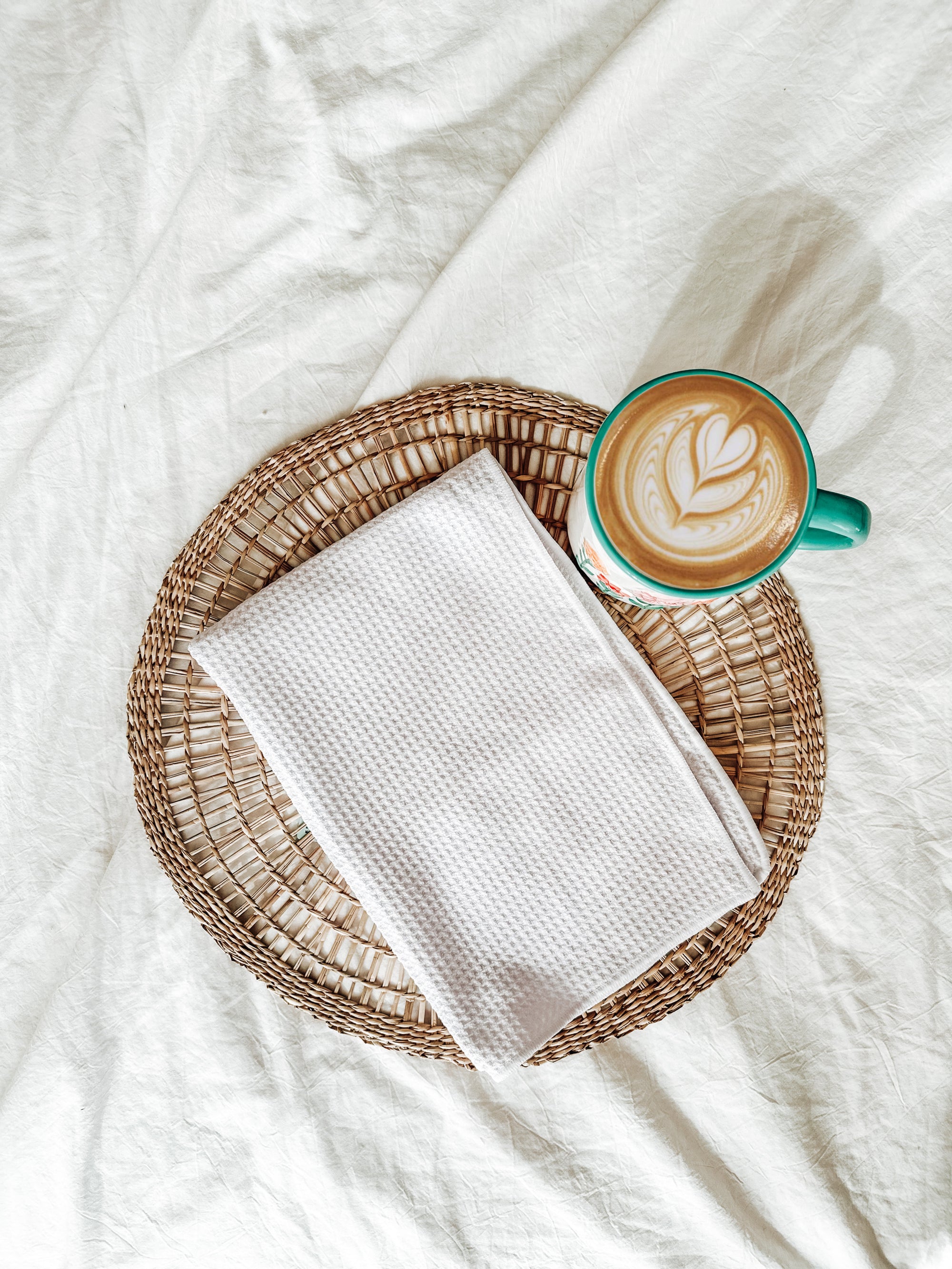 A high quality waffle knit kitchen towel with a cup of coffee on a soft white background.
